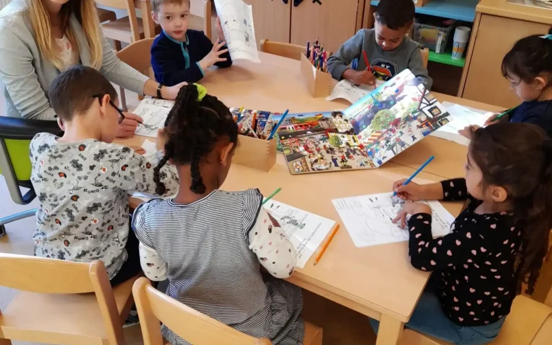 Eine Gruppe von Kindern samt Lebenshelfer beim Lernen