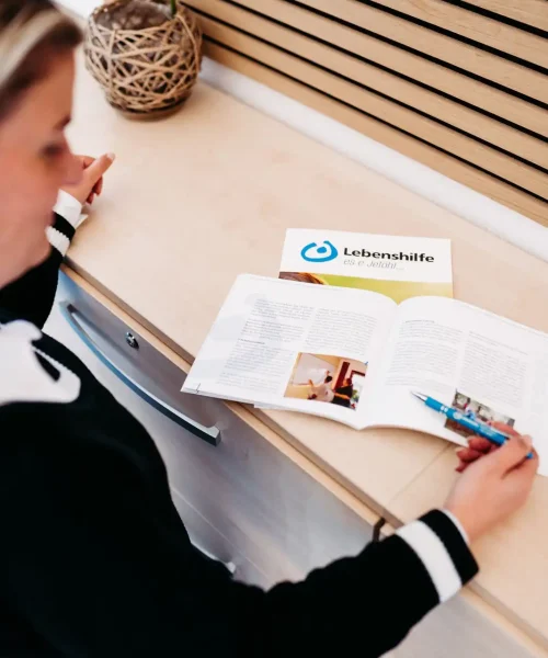 Frau zeigt auf etwas in einer Broschüre