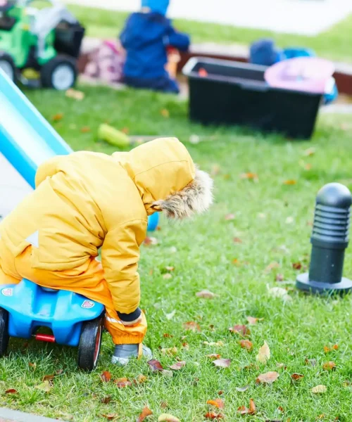 Kind das auf dem Rasen spielt
