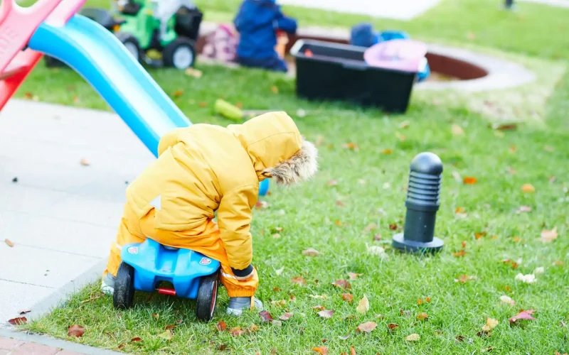 Kind das auf dem Rasen spielt