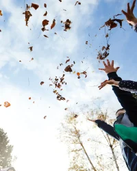 Kinder die Blätter in die Luft werfen