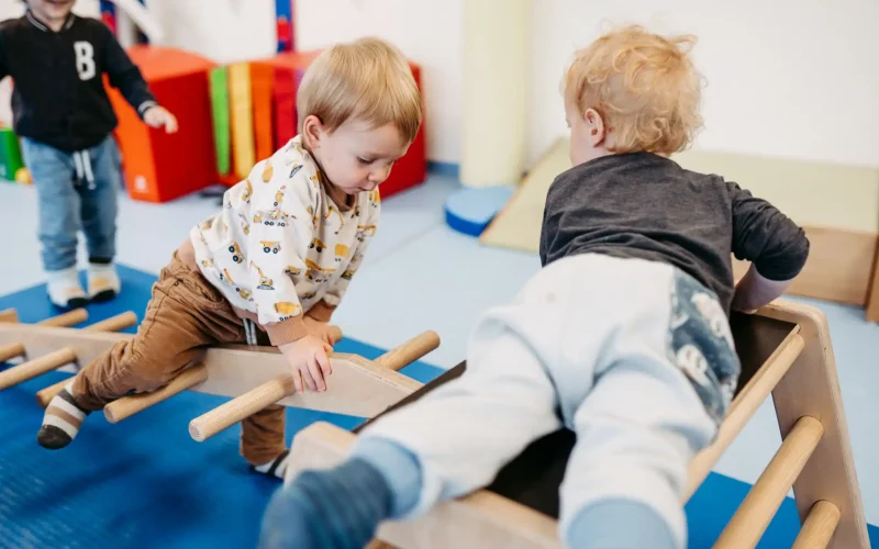 Kinder spielen zusammen auf einem Holzgerüst