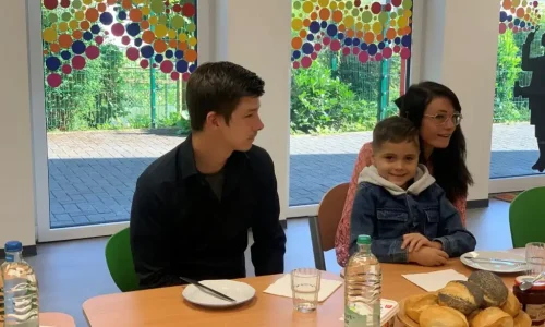 Kinder und Lebenshelfer beim Frühstück