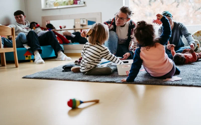Lebenshelfer kümmern sich um eine Gruppe Kinder und spielen mit ihnen