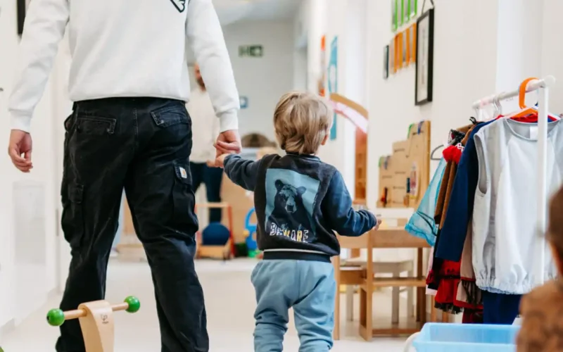 Lebenshelfer nimmt ein kleines Kind an die Hand