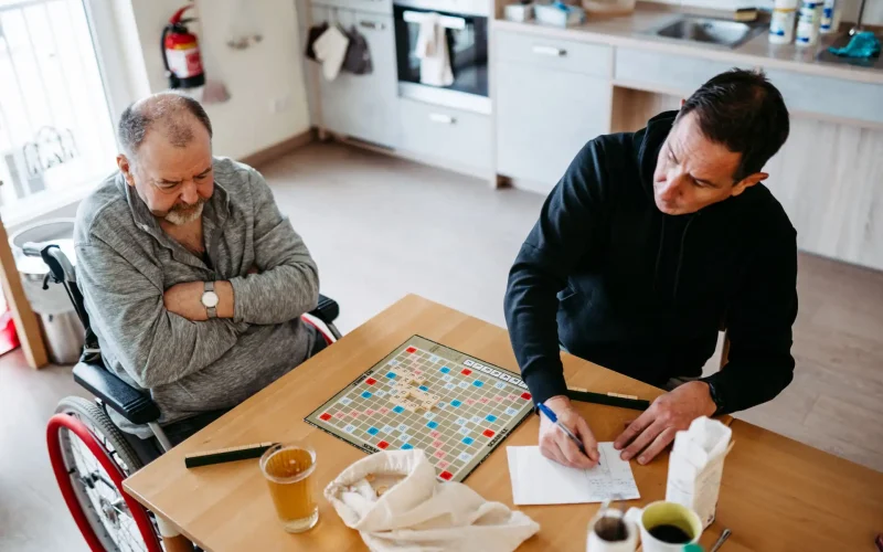 Lebenshelfer und Patient sitzen zusammen am Tisch