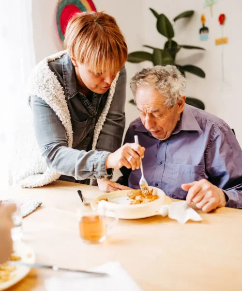 Lebenshelferin hilft Senioren beim essen