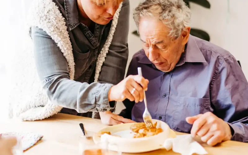 Lebenshelferin hilft Senioren beim essen