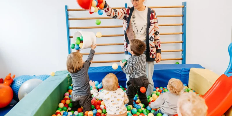 Lebenshelferin spielt mit Kindern im Bällebad