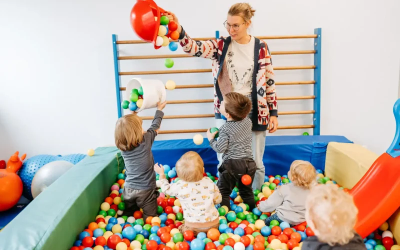 Lebenshelferin spielt mit Kindern im Bällebad