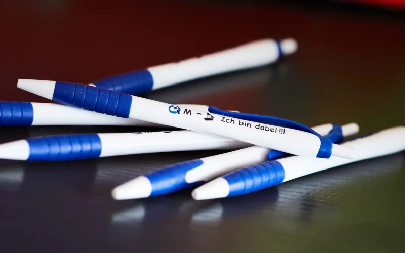 Mehrere QM-Kugelschreiber auf einem Haufen