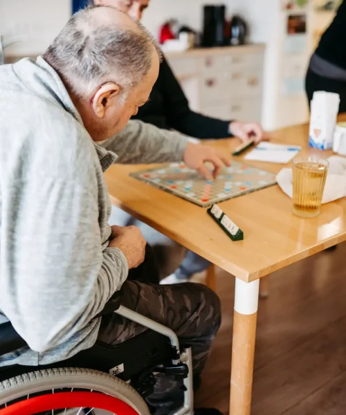 Patient spielt mit Lebenshelfer Scrabble