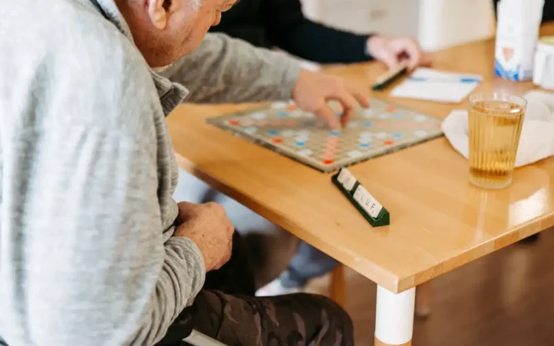 Patient spielt mit Lebenshelfer Scrabble