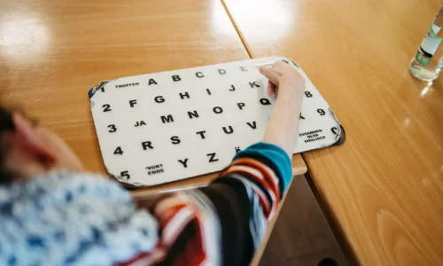 Patientin zeigt auf eine Tafel mit Buchstaben