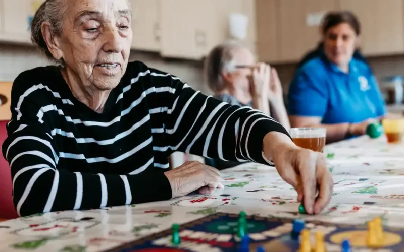 Seniorin spielt 'Mensch ärger dich nicht'