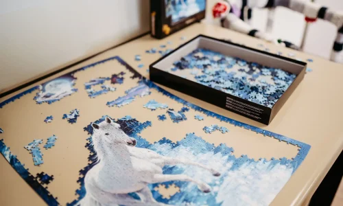 Tisch mit halb aufgebauten Puzzle eines Pferds